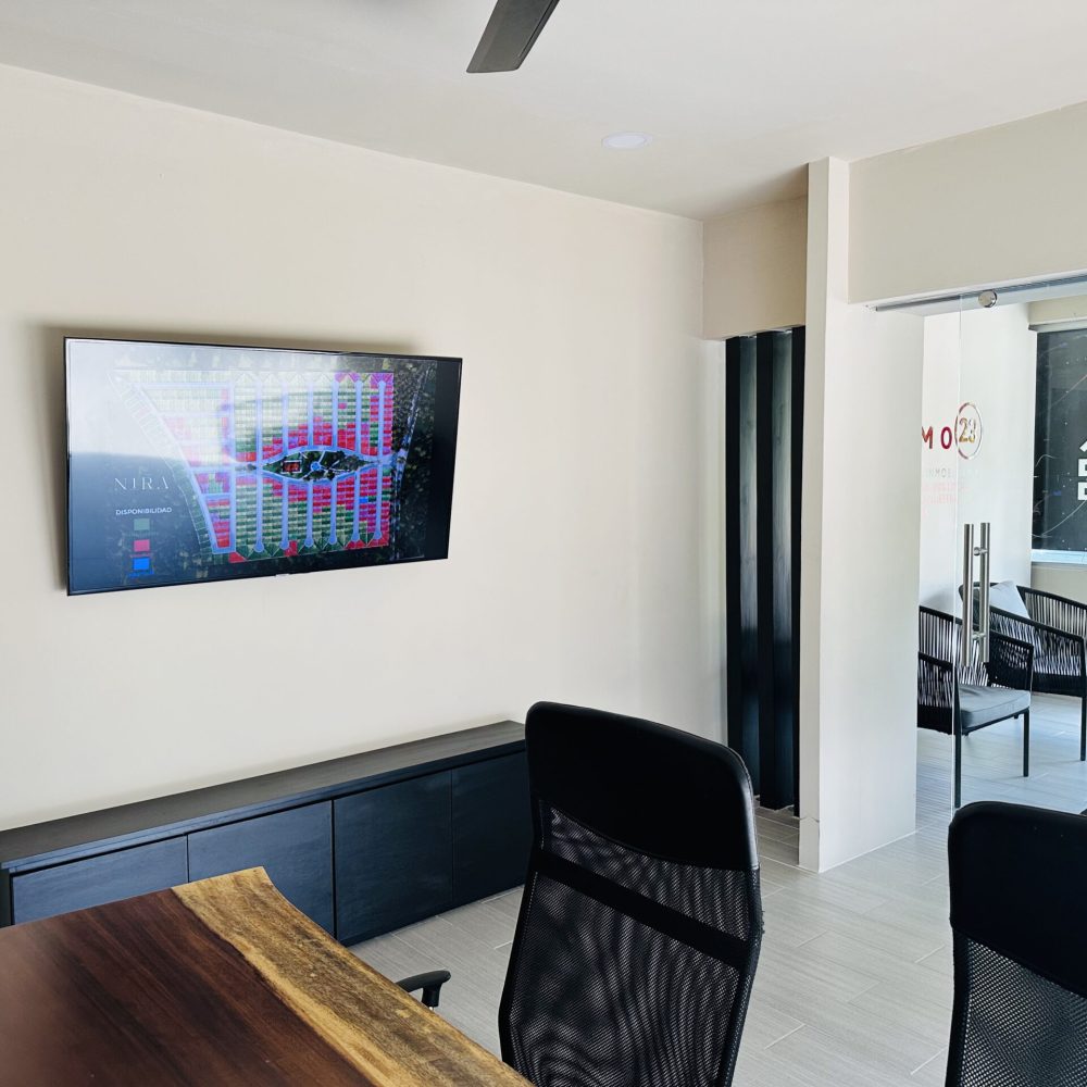 Sala de juntas equipada con pantalla para la presentación de desarrollos inmobiliarios y venta de terrenos en Huatulco.